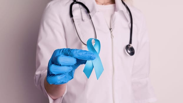 Female doctor holding a blue ribbon in her hands - image