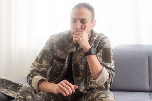 Nervous male military suffering depression, sitting alone at home, PTSD concept. High quality photo