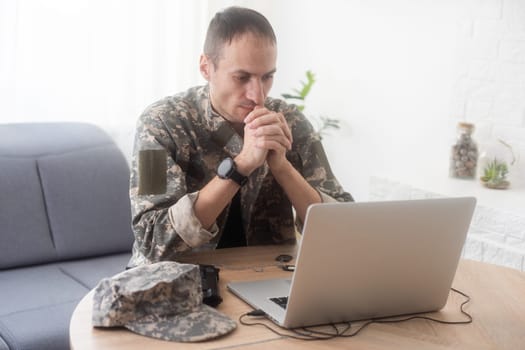 Portrait of young army soldier with a laptop. High quality photo