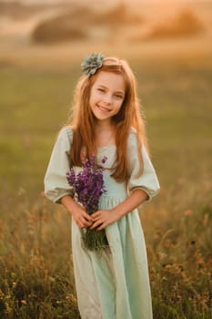 a little girl in a light green dress with a bouquet of lavender in a field at sunset.