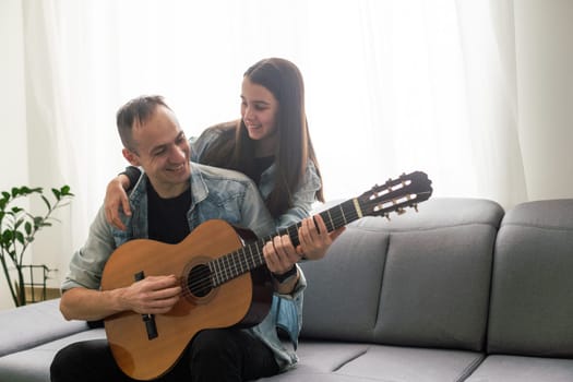 Happy family Father and daughter playing guitar. Father's day. High quality photo