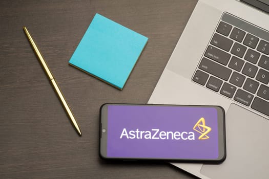 Tula, Russia - September 17, 2020: Logo AstraZeneca on a smartphone near modern laptop on a table.