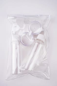 Plastic containers. Travel set on a white background. Plastic bottles for cream, shampoo in a sealed bag. Top view.