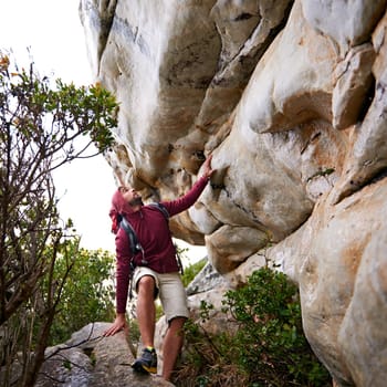 Man, mountain climbing and fitness for travel outdoor, freedom and journey with adventure, focus and strong. Determination, concentration and trekking with challenge, peak and rocks on rough terrain.