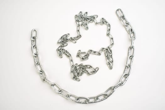 New shiny metal chain lies on a white background.