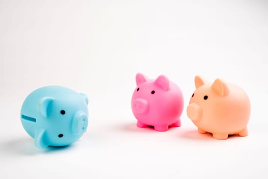 Growing investment - three piggy banks different color isolated on white