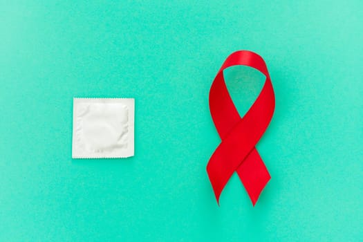 Red ribbon with a condom on a blue background - image