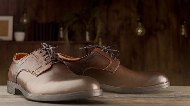 Fashionable men's classic brown shoes on a wooden background.