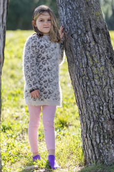 Cute little girl 7 years old in the summer park - portrait near tree