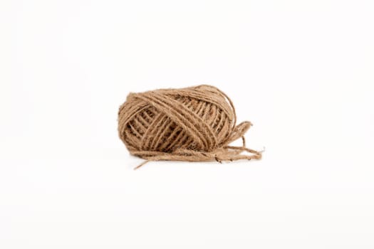 A ball of coarse thread on a white background side view