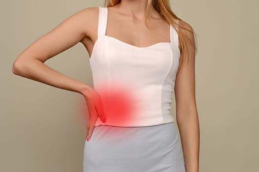 A young woman is experiencing pain in the abdomen on the right side.