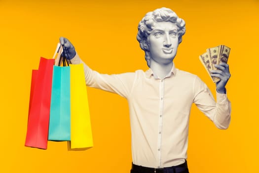 Abstract modern collage. The man with the plaster head of David showing his shopping bag and money on yellow background