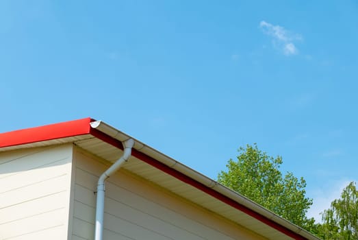 Red gutter on the roof top of house.