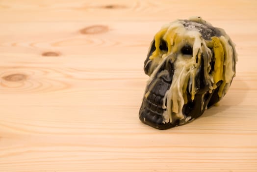 Decorative Skull with smudges of wax candles wooden table