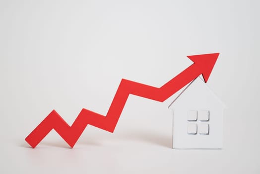 a red up arrow and house. The concept of the rising price of real estate