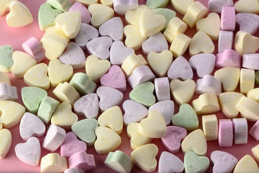Delicious heart shaped candies on white table, closeup 1