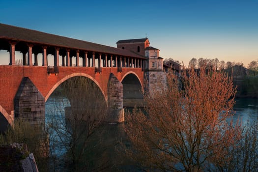 Amazing view of Ponte Coperto (covered bridge) is a bridge over the Ticino river in Pavia at sunset, Lombardy, Pavia, Italy