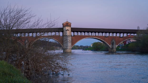 Wonderful view of Ponte Coperto (covered bridge) is a bridge over the Ticino river in Pavia at blue hour, Lombardy, Pavia, Italy