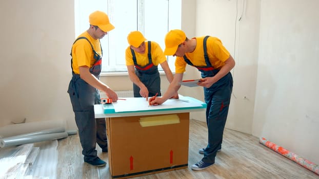 Preparatory phase of house renovation. Working group is studying a plan of apartment. Business professional contractor.