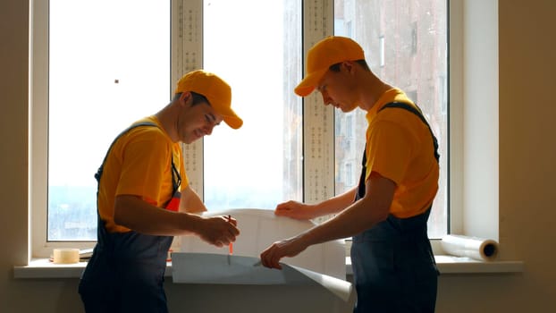 Two workers are discussing the construction work. Workers look project.