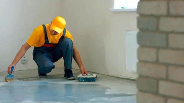 Builder processing concrete. Worker make renovation of apartment.