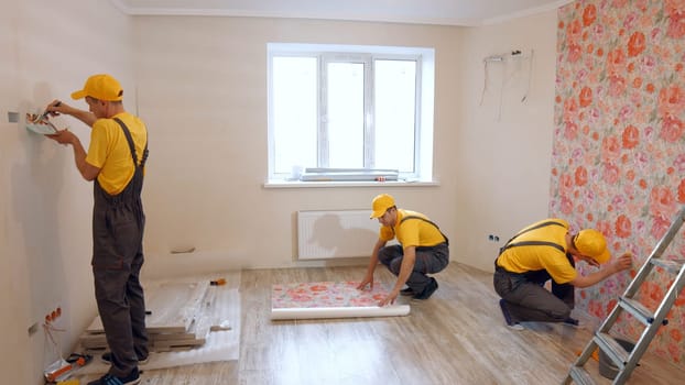 Team of builders make repairs living room. Renovated apartment.