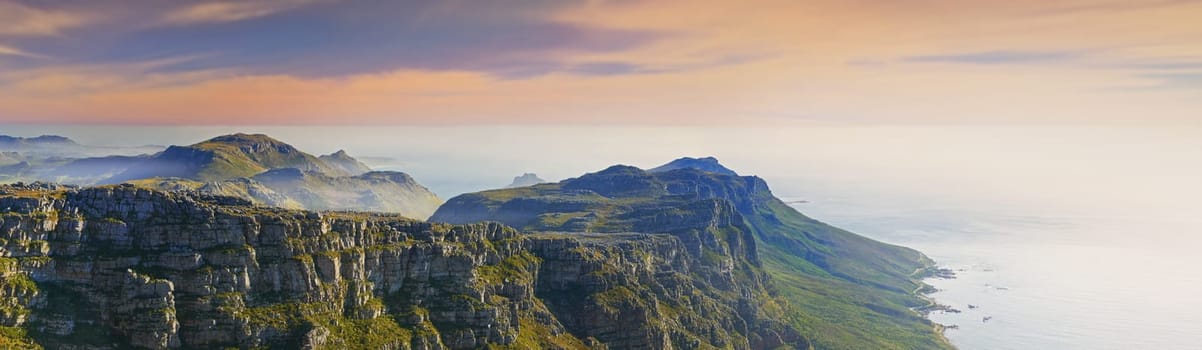 Mountain, island and clouds on sunset sky at ocean with natural landscape, hill and beach at travel banner. Nature, fog and sustainable environment with earth, sea and tropical holiday destination.