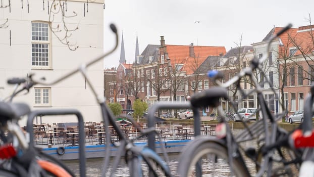 Bicycles parked alongside a channel on beautiful old buildings background.