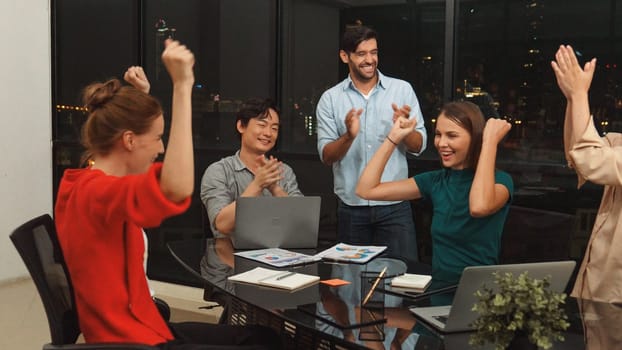 Businesspeople putting hands together and clapping hands to celebrate successful project at modern office with night city view. Group of manager with stacks of hands. Teamwork, trust. Tracery