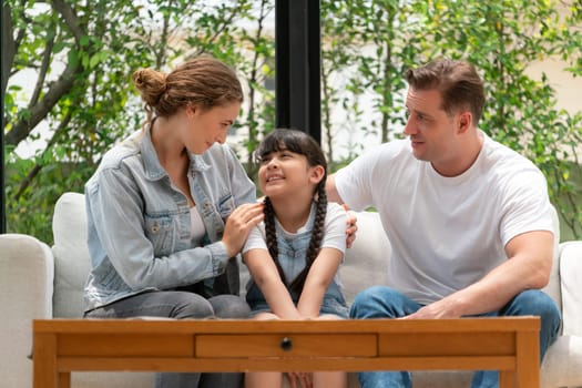 Parents comforting their daughter with loving hug, helping her feel secure and protected from fear, rest her head on shoulder. Happy family love and child care support concept. Synchronos