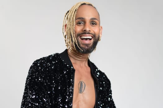 Confident black gay man with make up smiling isolated on white background, dressed black jacket with sequins. Exudes sense of pride and individuality. Diversity power of personal style