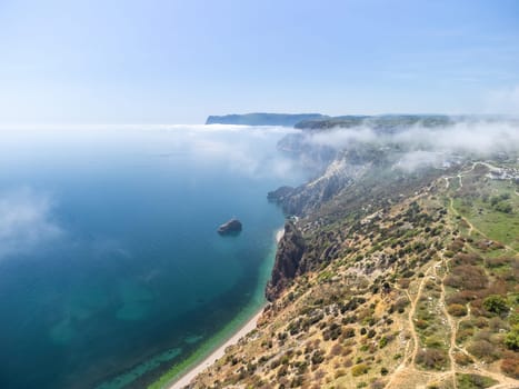 Blue sky with white clouds over calm summer panorama of the sea. Drone aerial view. Abstract aerial nature summer ocean sunset sea and sky background. Horizon. No people. Holiday and vacation concept