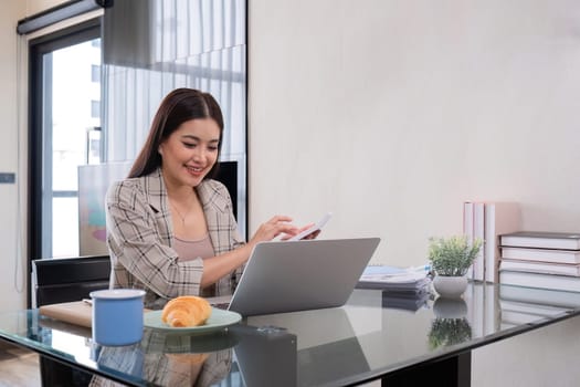 Young business woman sitting at home working on laptop by working online..