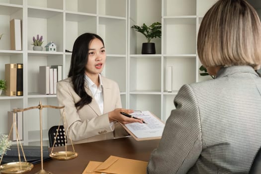 Lawyer and businesswomen discussing and introducing Providing legal advice regarding signing insurance contracts or financial contracts.