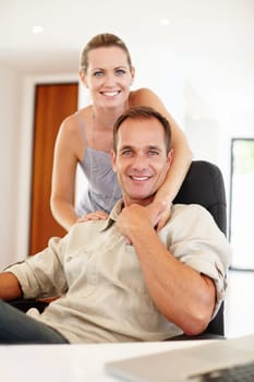 Smile, portrait and couple in hug on chair, love and proud of marriage milestone in home. Happy, embrace and people for relationship achievement, romance and bonding in apartment for enjoyment.