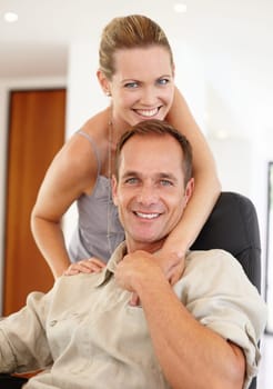 Care, portrait and couple in hug on chair, love and proud of marriage milestone in home. Happy, embrace and people for relationship achievement, romance and bonding in apartment for commitment.