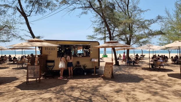 Rayong Thailand 13 March 2024,A diverse group of people gather excitedly in front of a vibrant food truck, eagerly awaiting their turn to sample the delicious street food offerings.