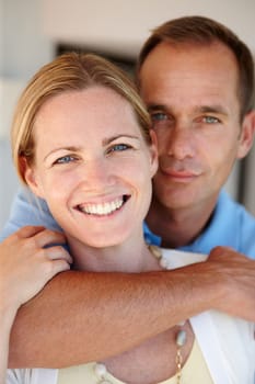 Smile, portrait and couple in hug to relax, love and proud of marriage milestone in home. Happy, embrace and people for relationship achievement, romance and bonding in apartment for enjoyment.