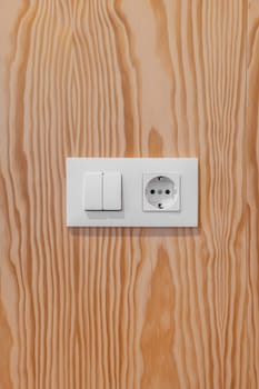 Wooden wall with light switch and socket.