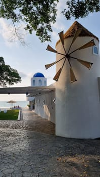Bangsaray Pattaya Thailand 28 February 2024, A majestic white building stands tall with a windmill spinning gracefully on top, capturing the essence of a European countryside.