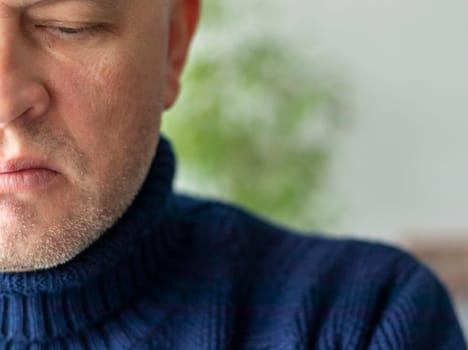 Portrait of the mid aged man with grey hair, wearing warm, dark blue sweater