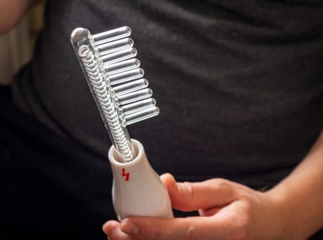 Close up shot of the high frequency comb tool for hair and scalp treatment.