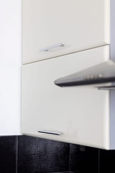 Close up shot of the kitchen cabinets and electric exhaust in the kitchen
