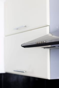 Close up shot of the kitchen cabinets and electric exhaust in the kitchen