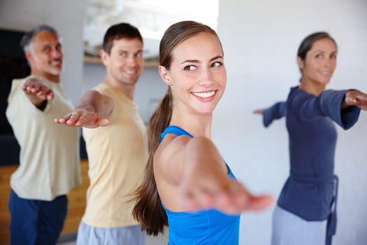 People, yoga and class with smile, fitness and wellness for mindfulness, wellbeing and health. Men, women and session at gym, studio and together for physical, activity and training in Virabhadrasana.