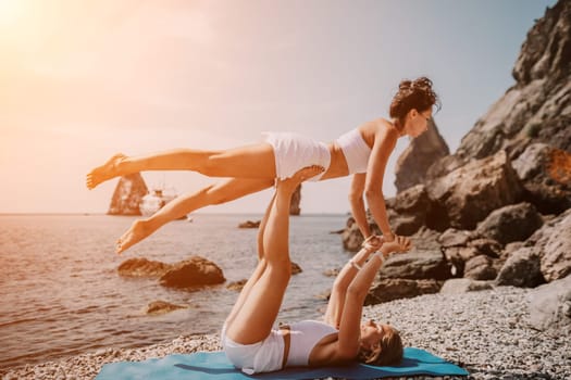 Woman sea yoga. Back view of free calm happy satisfied woman with long hair standing on top rock with yoga position against of sky by the sea. Healthy lifestyle outdoors in nature, fitness concept.