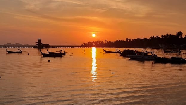 Koh Mook Thailand Multiple small boats peacefully float on the calm waters, creating a harmonious scene of tranquility and unity.