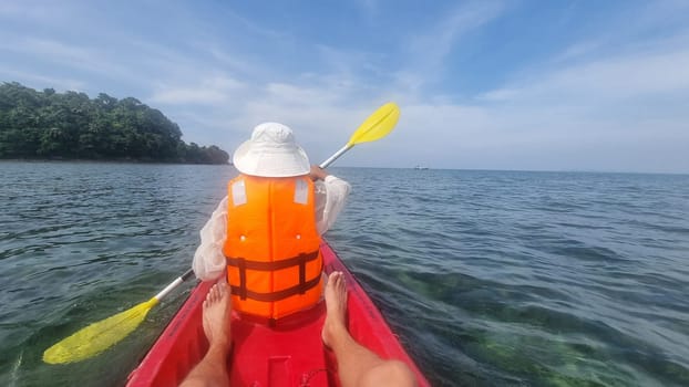 A person gracefully paddles a colorful kayak through the tranquil waters, surrounded by natures beauty. Koh Libong Thailand