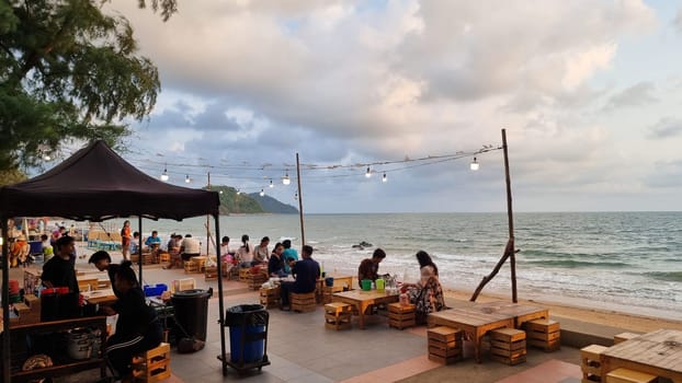 Chantaburi Thailand 15 March 2024, A diverse group of individuals stands on a sandy beach beside the vast ocean, gazing out at the horizon with a sense of wonder and unity.