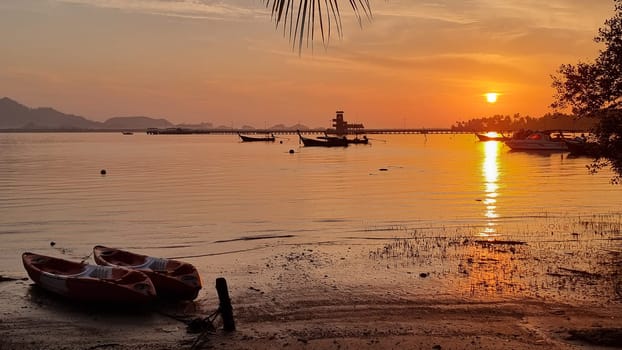 A colorful boat rests peacefully on the sandy beach, overlooking the vast ocean. Koh Mook Thailand